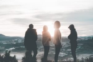 group of friends looking away towards sunset